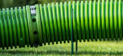 Nærbilde av en grønn Zippi tunnel som løftes opp fra plenen ved hjelp av Zippi støttebøyler.