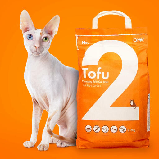 En pose tofu kattesand med en hvit katt bak