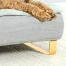 Nærbilde av hund som sitter på Omlet Topology hundeseng med bolster bed topper og Go ld skinneføtter