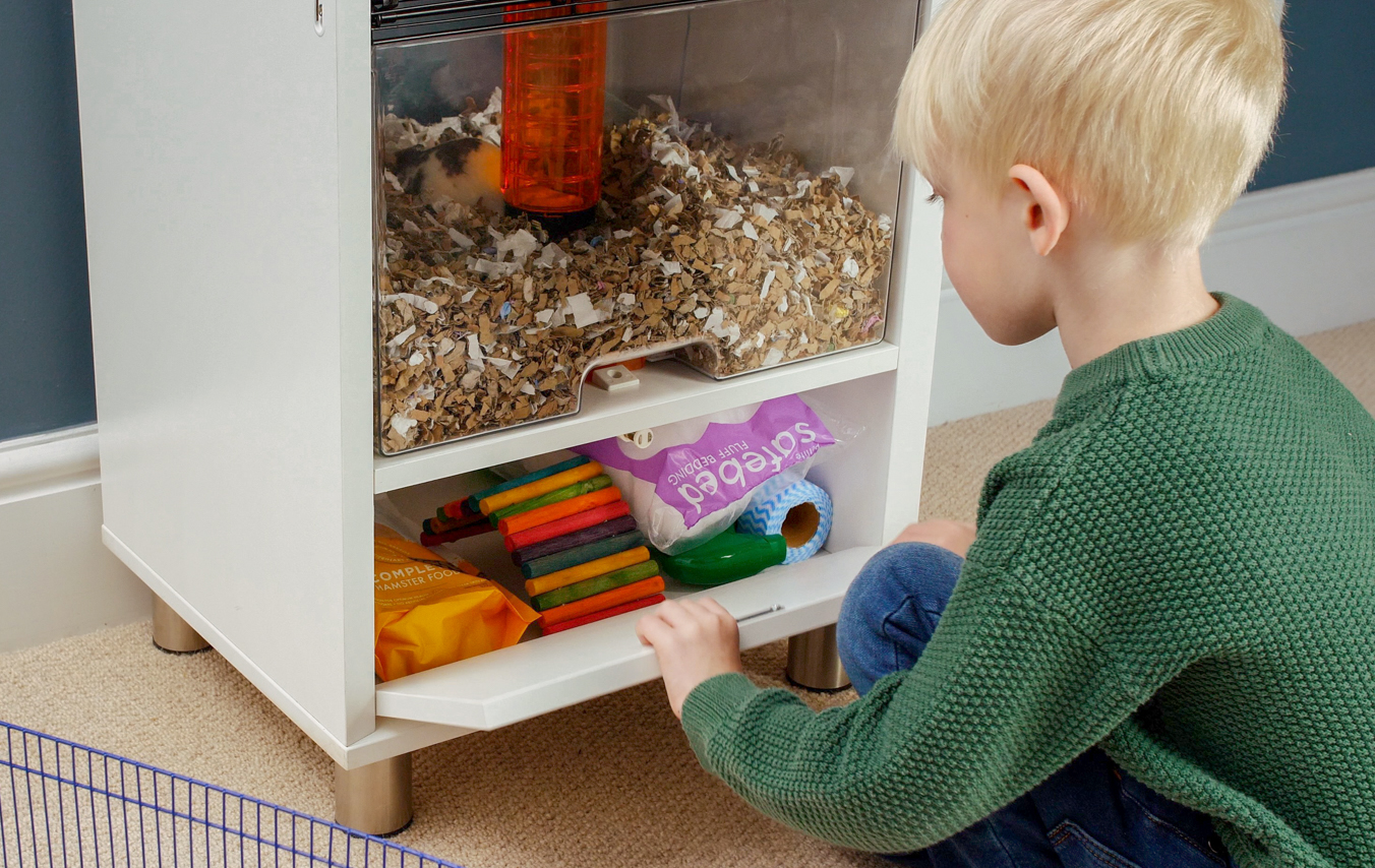 Barn som oppbevarer bunnmateriale i Qute hamsterbur oppbevaringsrommet